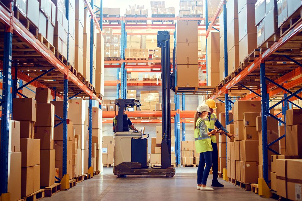 Workers and forklift in a large warehouse